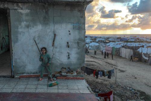 epa12774705 A displaced Palestinian girl plays outside her family's shelter, located in the remains of a destroyed building among makeshift tents during the holy month of Ramadan, near the beach in Gaza City, 24 February 2026. Muslims around the world celebrate the holy month of Ramadan by praying during the nighttime and abstaining from eating, drinking,...