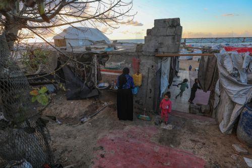 epaselect epa12774677 A displaced Palestinian woman prepares iftar in the remains of a destroyed building among makeshift tents before breaking their fast during the holy month of Ramadan, near the beach in Gaza City, 24 February 2026. Muslims around the world celebrate the holy month of Ramadan by praying during the nighttime and abstaining from eating,...