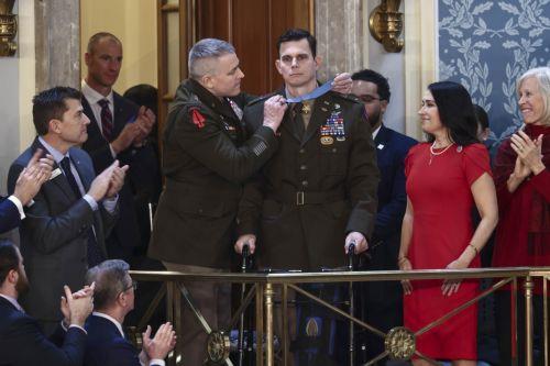 epa12775419 Chief Warrant Officer Eric Slover (C-R), who was wounded in the Maduro abduction raid, receives the Medal of Honor as he is recognized by US President Donald Trump during his State of the Union address before a joint session of Congress in the House of Representatives chamber of the US Capitol in Washington, DC, USA, 24 February 2026.  EPA/JIM...