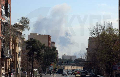 epa12793856 People drive past as smoke rises after airstrike in a street central Tehran, Iran, 04 March 2026. A joint Israeli and US military operation continues to target multiple locations across Iran since the early hours of 28 February 2026.  EPA/ABEDIN TAHERKENAREH