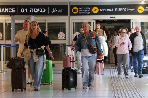 epa12796670 Passengers carrying their luggage react as they leave the arrival terminal at Ben Gurion International Airport, near Tel Aviv, Israel, 05 March 2026. The Israeli Aviation Authority has begun a phased reopening of civilian airspace, operating special repatriation flights for an estimated 100,000 Israeli citizens stranded abroad since the five-day...