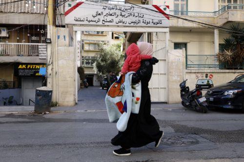 epa12805922 A woman carries her child as she flees their home following Israeli airstrikes in Beirut, Lebanon, 09 March 2026. The Israeli military stated it is conducting strikes across the country targeting Hezbollah infrastructure and personnel. According to the Disaster Management Unit of the Lebanese government, as of 08 March 2026, more than 115,000...