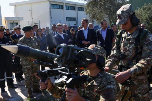 epa12806505 French President Emmanuel Macron (C-L), Cypriot President Nikos Christodoulides (C-R), and Greek Prime Minister Kyriakos Mitsotakis (C) watch members of the military at Paphos military airport, in Paphos, Cyprus, 09 March 2026, on the day of Macron's visit to show France's solidarity after recent drone attacks amid the U.S.-Israeli conflict with...