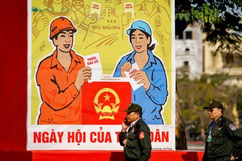 epa12808197 People walk past signage for the upcoming general election in Hanoi, Vietnam, 10 March 2026. Nearly 73.5 million voters in Vietnam are expected to cast ballots on 15 March to elect deputies to the 16th National Assembly and members of local People's Councils for the 2026–2031 tenure, according to state media.  EPA/LUONG THAI LINH