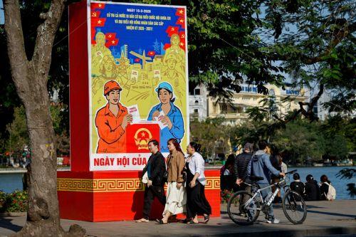 epa12808198 People walk past signage for the upcoming general election in Hanoi, Vietnam, 10 March 2026. Nearly 73.5 million voters in Vietnam are expected to cast ballots on 15 March to elect deputies to the 16th National Assembly and members of local People's Councils for the 2026–2031 tenure, according to state media.  EPA/LUONG THAI LINH