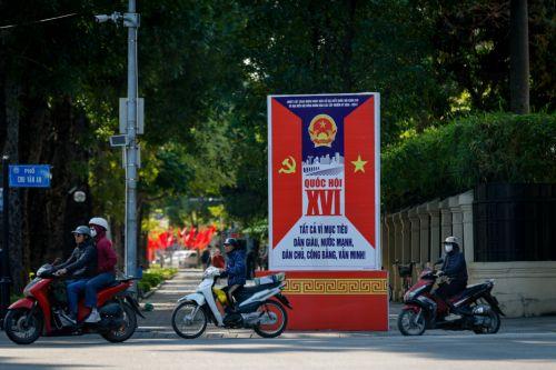 epa12808202 People ride motorbikes past signage for the upcoming general election in Hanoi, Vietnam, 10 March 2026. Nearly 73.5 million voters in Vietnam are expected to cast ballots on 15 March to elect deputies to the 16th National Assembly and members of local People's Councils for the 2026–2031 tenure, according to state media.  EPA/LUONG THAI LINH