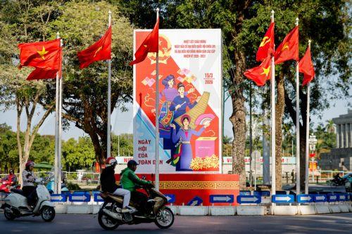 epa12808206 People ride motorbikes past signage for the upcoming general election in Hanoi, Vietnam, 10 March 2026. Nearly 73.5 million voters in Vietnam are expected to cast ballots on 15 March to elect deputies to the 16th National Assembly and members of local People's Councils for the 2026–2031 tenure, according to state media.  EPA/LUONG THAI LINH