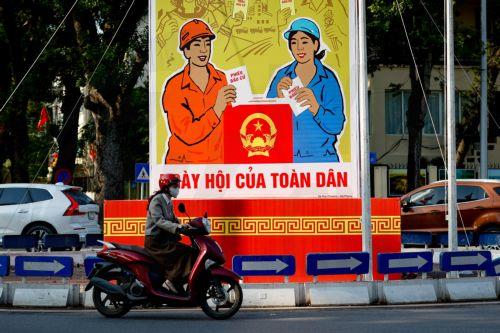 epa12808209 A girl rides a motorbike past signage for the upcoming general election in Hanoi, Vietnam, 10 March 2026. Nearly 73.5 million voters in Vietnam are expected to cast ballots on 15 March to elect deputies to the 16th National Assembly and members of local People's Councils for the 2026–2031 tenure, according to state media.  EPA/LUONG THAI LINH