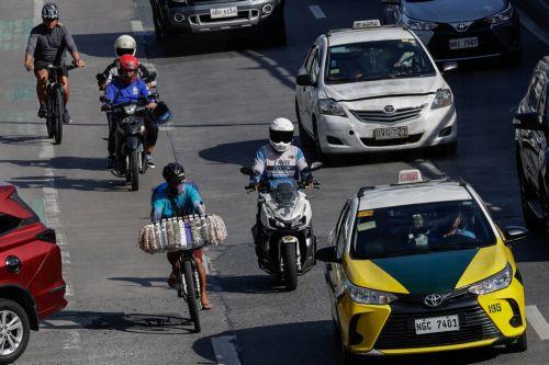 epa12808251 A vendor (L) on a bicycle travels along a main thoroughfare in Quezon City, Metro Manila, Philippines, 10 March 2026. As significant fuel price hikes hit the Philippines 10 March amidst ongoing Middle East tensions from conflict involving the United States, Israel and Iran, bicycles are expected to be used as alternative modes of transport by...