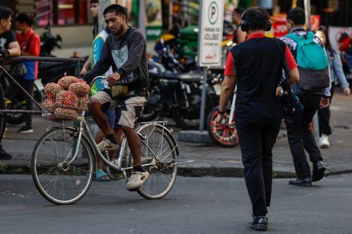 epa12808252 A vendor (L) on a bicycle travels through a market district in Quezon City, Metro Manila, Philippines, 10 March 2026. As significant fuel price hikes hit the Philippines 10 March amidst ongoing Middle East tensions from conflict involving the United States, Israel and Iran, bicycles are expected to be used as alternative modes of transport by...