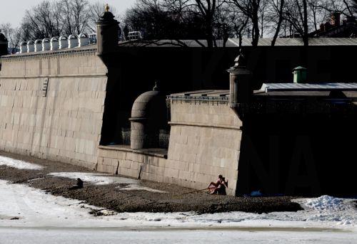 epa12811599 People take off their clothes to sunbathe on a sunny day near the wall of the Peter and Paul Fortress in St. Petersburg, Russia, 11 March 2026. Temperatures in St. Petersburg, Russia’s second-largest city, reach eleven degrees Celsius.  EPA/ANATOLY MALTSEV
