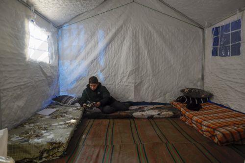 epa12811749 A boy reads a book inside a tent at a new shelter for displaced people inside the Camille Chamoun Sports City Stadium in Beirut, Lebanon, 11 March 2026. Lebanese authorities report more than 759,000 registered displaced since the escalation began on 02 March 2026, though the true number is likely higher as many stay with relatives or rent in...