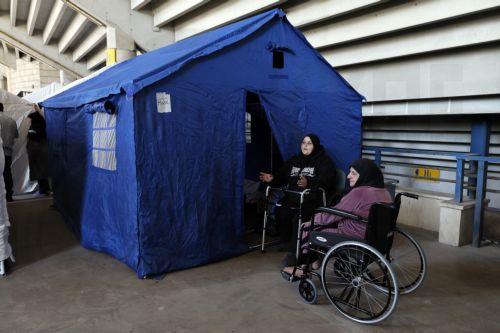 epa12811750 Disabled women in wheelchairs talk together inside the Camille Chamoun Sports City Stadium in Beirut, Lebanon, 11 March 2026. Lebanese authorities report more than 759,000 registered displaced since the escalation began on 02 March 2026, though the true number is likely higher as many stay with relatives or rent in safer areas.  EPA/WAEL HAMZEH