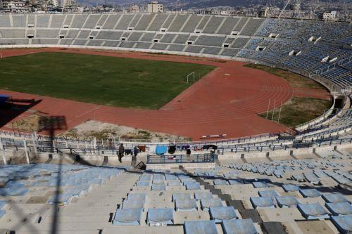 epa12811748 A displaced man waits for laundry to air-dry inside the Camille Chamoun Sports City Stadium in Beirut, Lebanon, 11 March 2026. Lebanese authorities report more than 759,000 registered displaced since the escalation began on 02 March 2026, though the true number is likely higher as many stay with relatives or rent in safer areas.  EPA/WAEL HAMZEH