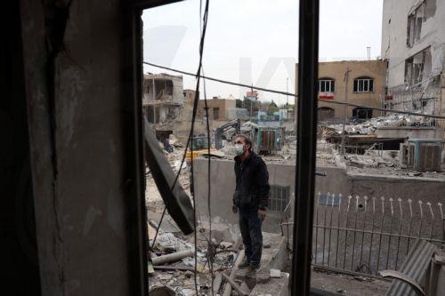 epa12821307 An Iranian man inspects a damaged residential building in southern Tehran, Iran, 15 March 2026. A joint Israeli and US military operation continues to target multiple locations across Iran since the early hours of 28 February 2026.  EPA/ABEDIN TAHERKENAREH