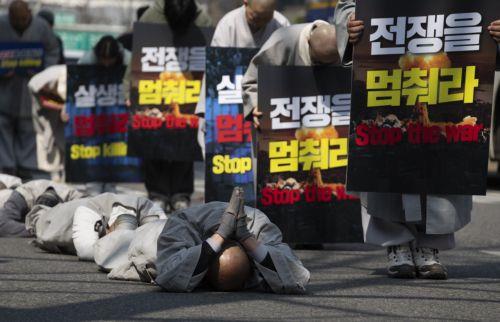 epa12826560 South Korean monks perform the Buddhist praying act of Dharna - walking three steps and making one bow - toward the US Embassy during a protest against US President Trump, in Seoul, South Korea, 17 March 2026. Protesters gathered to oppose Trump’s request for South Korea to send ships to the Strait of Hormuz.  EPA/JEON HEON-KYUN